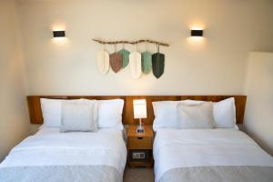 duas camas sentadas uma ao lado da outra num quarto em Casa Viento Hotel em Ciudad del Carmen