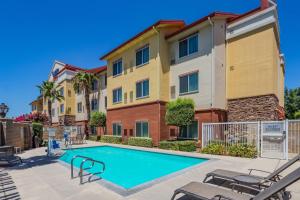 a swimming pool with patio furniture in front of a building at Fairfield Inn and Suites Turlock in Turlock