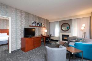 a hotel room with a bed and a desk with a television at Courtyard by Marriott Traverse City in Traverse City