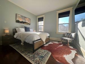 1 dormitorio con 1 cama, 1 silla y ventanas en Luxury Lenox Townhouse en Memphis