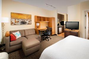 a living room with a couch and a desk with a television at TownePlace Suites by Marriott Lexington Park Patuxent River Naval Air Station in Lexington Park