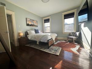 a bedroom with a bed and two windows at Luxury Lenox Townhouse in Memphis