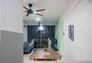 a living room with a ceiling fan and a table at Five H Family Service Apartment in Seri Kembangan