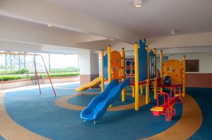 una sala de juegos con un tobogán y un parque infantil en Five H Family Service Apartment, en Seri Kembangan