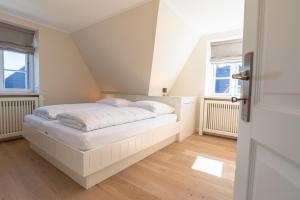 - une chambre avec un lit blanc et 2 fenêtres dans l'établissement Dwarslöper, à Wrixum