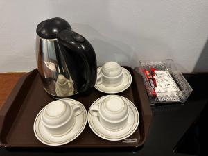a tray with plates and a coffee pot on a table at GOA INN HOTEL SDN BHD in Gua Musang