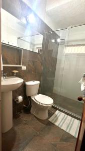 uma casa de banho com um WC, um chuveiro e um lavatório. em Céntrico-A pie del mar y del Casco histórico+A/C em Santa Marta