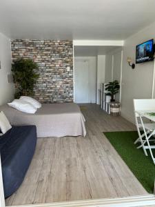 sypialnia z łóżkiem i ceglaną ścianą w obiekcie Studio Douceur Karamel 327 w mieście Belle-Allée