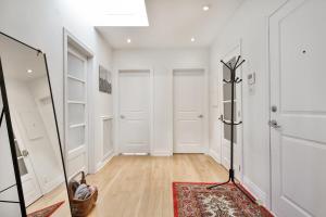 a hallway with white walls and a mirror at STUNNING full APARTMENTS - stocked KITCHENS - WASHER & DRYERS - WORKSPACE PROVIDED - FAST WIFI - LOCATED on the FAMOUS ST Denis street - Near METRO MONT ROYAL in Montreal