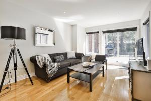a living room with a couch and a table at STUNNING full APARTMENTS - stocked KITCHENS - WASHER & DRYERS - WORKSPACE PROVIDED - FAST WIFI - LOCATED on the FAMOUS ST Denis street - Near METRO MONT ROYAL in Montreal
