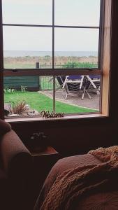 a bedroom window with a view of a picnic table at Rarangi Seaview On the Beach B&B in Blenheim