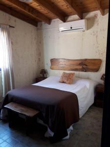 una camera con un grande letto con testiera in legno di Complejo Ramadas a Potrero de los Funes