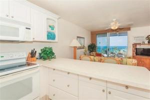 une cuisine avec des placards blancs et une vue sur l'océan. dans l'établissement Full Ocean Sunset View, Fully Equipped 6th Floor Condo KV602, à Kailua-Kona