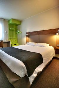 ein Schlafzimmer mit einem großen weißen Bett mit einer schwarzen Decke in der Unterkunft Campanile Paris Ouest - Chaville in Chaville