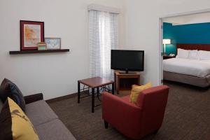 een hotelkamer met een bed, een bank en een tv bij Residence Inn Louisville East in Louisville