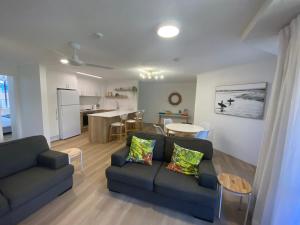 a living room with a couch and a kitchen at Enderley Gardens Resort in Gold Coast