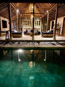a house with a swimming pool and a living room at Bohio Villas Gili Air in Gili Islands