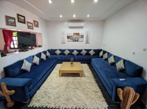 - un salon avec un canapé bleu et une table dans l'établissement Villa Dar Sukar, à Marrakech