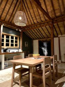 a wooden table and chairs in a kitchen with a ceiling at Bohio Villas Gili Air in Gili Islands