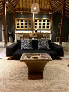 a living room with a black couch and a table at Bohio Villas Gili Air in Gili Islands