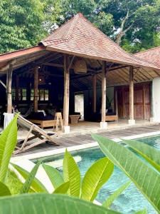 a pavilion with a pool in front of a house at Bohio Villas Gili Air in Gili Islands