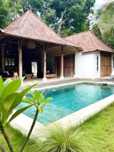a swimming pool in front of a house at Bohio Villas Gili Air in Gili Islands
