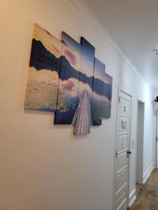 a group of five paintings hanging on a wall at Rose view guest house in Lisbon