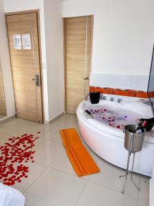 a bathroom with a white tub with red hearts on the floor at Hotel Cabreromar By GEH Suites in Cartagena de Indias