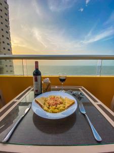 un plato de pizza y una copa de vino en una mesa en Hotel Cabreromar By GEH Suites, en Cartagena de Indias
