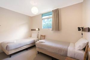 2 Betten in einem Zimmer mit Fenster in der Unterkunft Sea Home With a View at Pambula Beach-Pet Friendly in Pambula Beach
