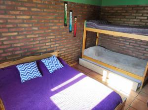 a room with two bunk beds and a brick wall at Cabañas Los Lúpulos in El Bolsón