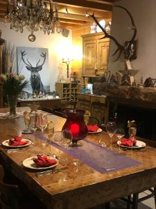 a table with wine glasses and a deer head on the wall at Chalet Esprit in Morillon