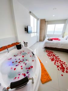 a bathroom with a bath tub with red hearts on the floor at Hotel Cabreromar By GEH Suites in Cartagena de Indias