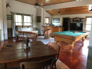 a living room with a pool table and a tv at Mucho Gusto in Bandera