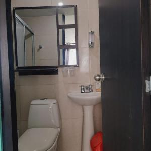 een badkamer met een toilet, een wastafel en een spiegel bij Apartamento turístico Guaduales del Cafe in Montenegro