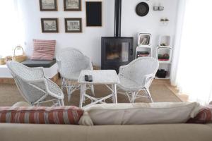 sala de estar con sillas blancas y sofá en Laranjal Farm House - Casa da Lareira, en Faro