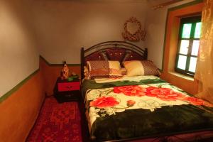 Un dormitorio con una cama con flores. en Tigmino Maison D'or, en Tafraoute