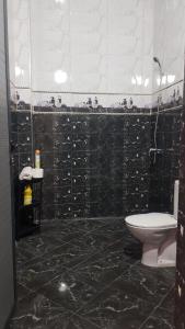 a black tiled bathroom with a toilet and a sink at Dream House Sidi Ifni in Sidi Ifni