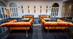 a row of brown leather couches in a room at Prestige Hotel Budapest in Budapest