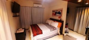 1 dormitorio con 1 cama y TV en Departamento Macro en Mendoza