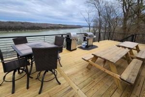eine Terrasse mit einem Picknicktisch und einem Grill in der Unterkunft Lakeview Happy Place - 10 Person House with HOT TUB on Lake Cumberland in Burnside