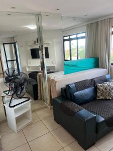 a living room with a couch and a bed at Lindo flat sem custos adicionais in Natal