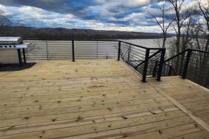 a large wooden deck with a view of a lake at Lakeview Happy Place - 10 Person House with HOT TUB on Lake Cumberland in Burnside