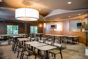 un restaurante con mesas, sillas y TV en SpringHill Suites Hampton, en Hampton