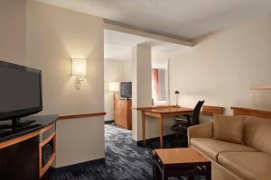 a living room with a couch and a room with a desk at Fairfield Inn & Suites by Marriott Tupelo in Tupelo