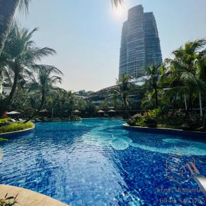 a large swimming pool with palm trees and a tall building at GELANG PATAH Forest City-Ataraxia Park 3 in Gelang Patah