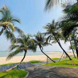 uma vista para uma praia com palmeiras e um baloiço em GELANG PATAH Forest City-Ataraxia Park 3 em Gelang Patah