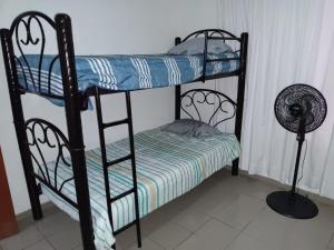 a bedroom with two bunk beds and a fan at Bonita casa amueblada para 12 personas a 3 Kms del centro Cuernavaca in Cuernavaca