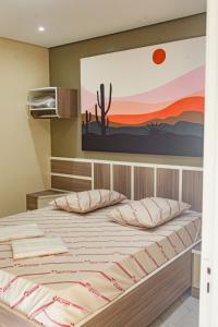 um quarto com uma cama com um quadro na parede em Hotel Tenda Obsession em São Paulo