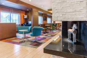 a lobby with a fireplace and chairs and tables at Fairfield Inn & Suites Sioux Falls in Sioux Falls